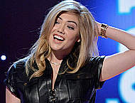 Kate Upton posing in tight leather dress