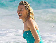 Naomi Watts in green swimsuit on a beach